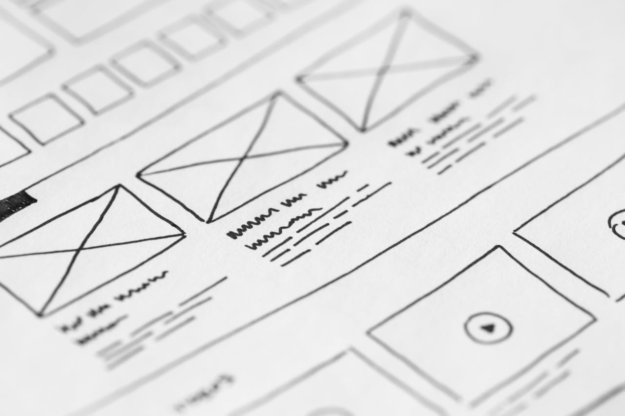 discover Detailed close-up of a hand-drawn wireframe design on paper for a UX project.