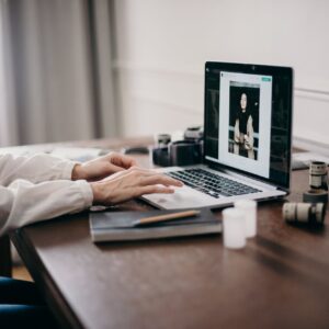 A freelancer working on a laptop in a cozy home office, focusing on creative design tasks.